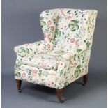 A Victorian wing framed armchair upholstered in white and floral tapestry materialSlight stain to