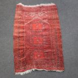 A red ground Afghan rug with 3 diamonds to the centre within a multi row border 150cm x 98cm Some