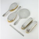 A silver engine turned dressing table set comprising hand mirror, 2 clothes brushes, 2 hair