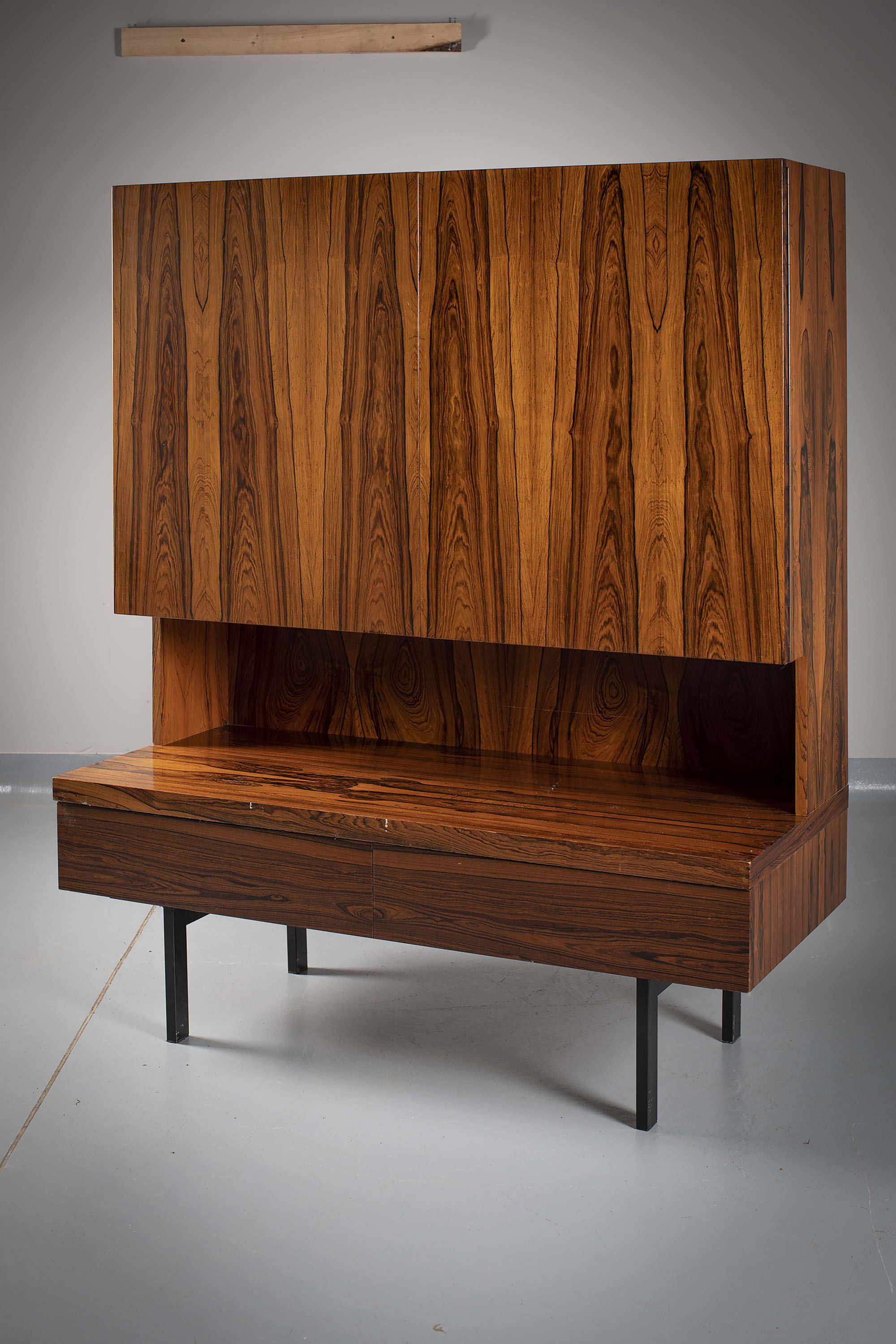 A ROSEWOOD SIDE CABINET, DANISH 1970s, the cupboard doors, above a shelf and drawer, on metal