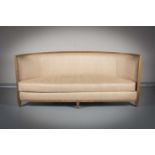 A CRESCENT SHAPED UPHOLSTERED SOFA, by Andree Putman