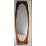 A ROSEWOOD MIRROR, ITALIAN 1960s, with shaped form, 46cm (w) x 121cm (h).