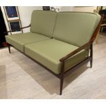 A DANISH SETTEE, 1970's WITH RAILED BACK , SHAPED ARMS ON TAPERING LEGS.