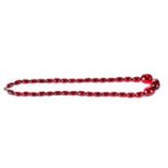 A GRADUATED STRING OF POLISHED RED AMBER BEADS, approximately 42 grams, 20 ins long.