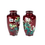 A PAIR OF JAPANESE RED GROUND CLOISONNE ENAMEL VASES decorated with flowers and leaves,
