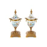 A PAIR OF LATE 19TH CENTURY CONTINENTAL PORCELAIN AND ORMOLU MOUNTED URNS polychrome decorated with