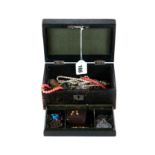 A BLACK LEATHER JEWELLERY BOX containing a 9ct gold "BABY" BROOCH,