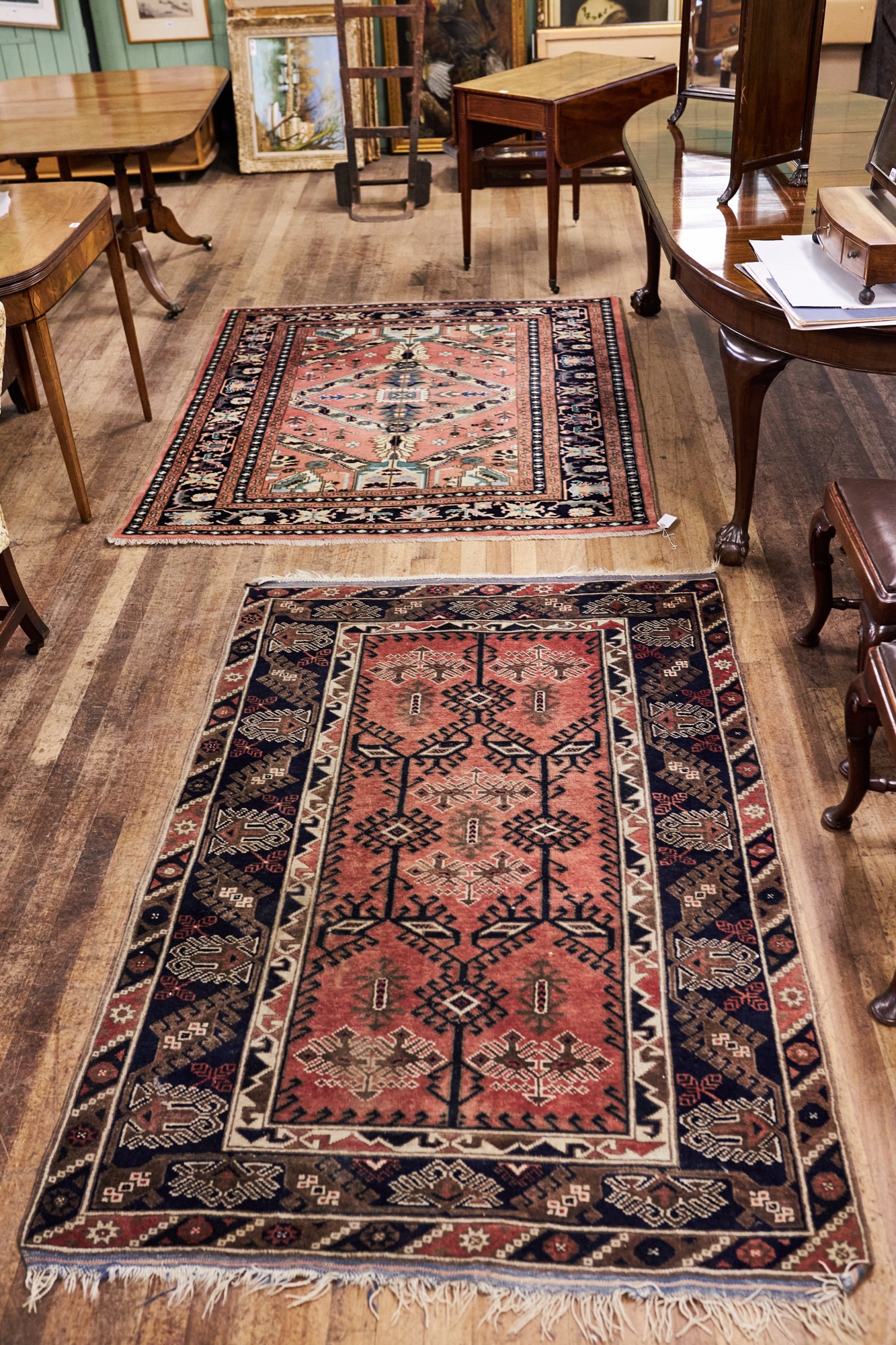 A 20TH CENTURY CORAL GROUND CAUCASIAN RUG with central foliate panel and six outer guard stripes,