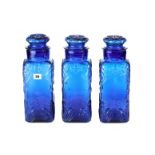 A SET OF THREE VINTAGE COBALT BLUE APOTHECARY JARS AND COVERS with moulded floral decoration,