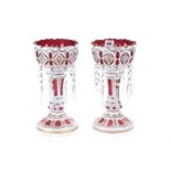 A PAIR OF 20TH CENTURY BOHEMIAN RUBY AND WHITE OVERLAY LUSTRES with panels of floral decoration,