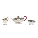 AN ART DECO DESIGN THREE PIECE SILVER TEA SET, comprising:- Teapot, cream jug and sugar basin,