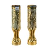 A PAIR OF 1914-18 BRASS TRENCH ART SHELL VASES embossed with birds on boughs, 13 1/4 ins high.