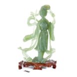 A CHINESE TRANSLUCENT GREEN HARDSTONE FIGURE OF GUANYIN holding a sword and flower,