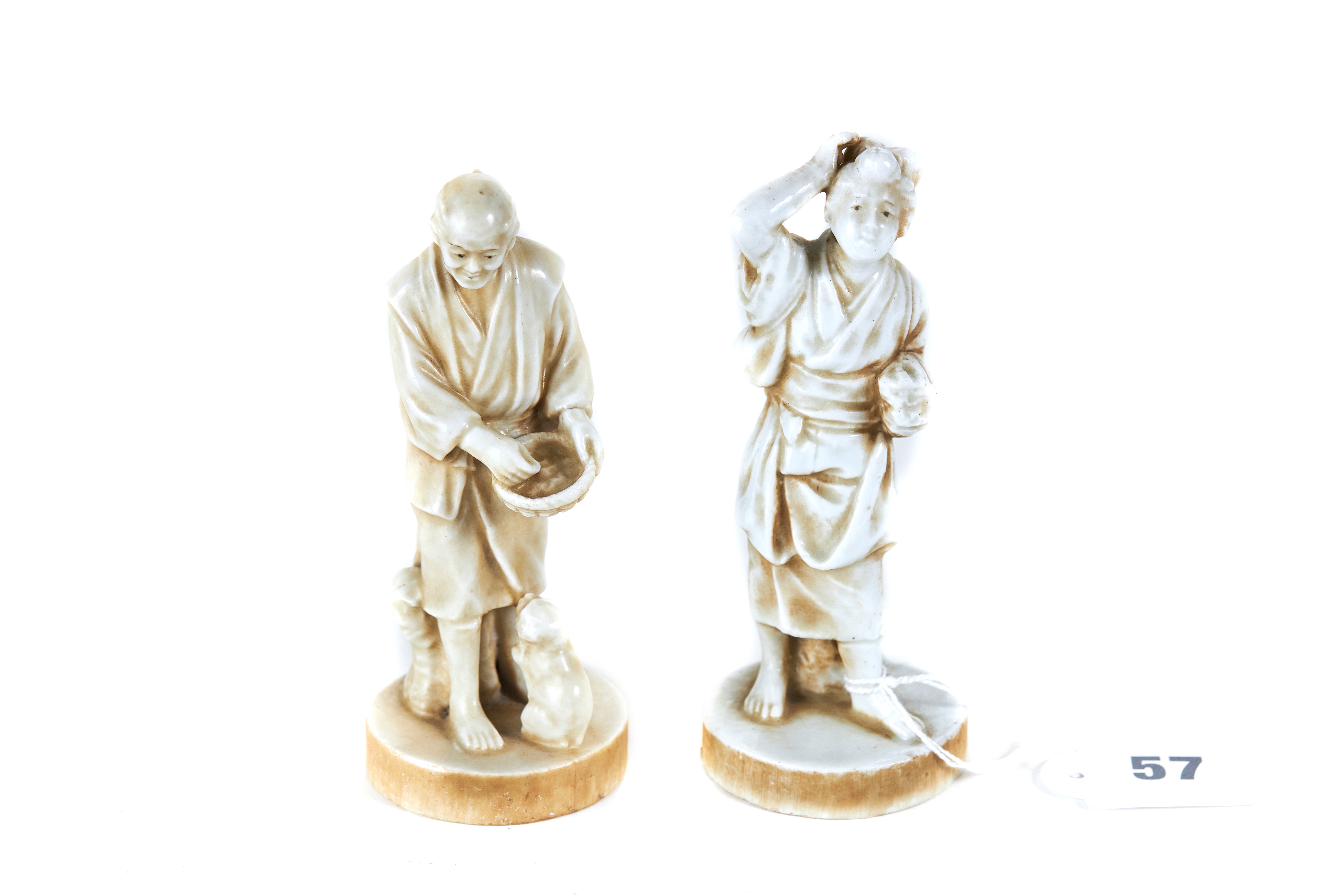 A PAIR OF LATE 19TH/EARL 20TH CENTURY JAPANESE PORCELAIN FAUX-IVORY FIGURES each on simulated tusk