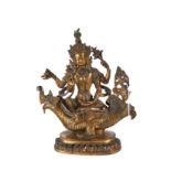 A FINE 19TH/20TH CENTURY SINO-TIBETAN GILDED BRASS AND JEWEL SET FIGURE OF A FOUR ARM DEITY seated