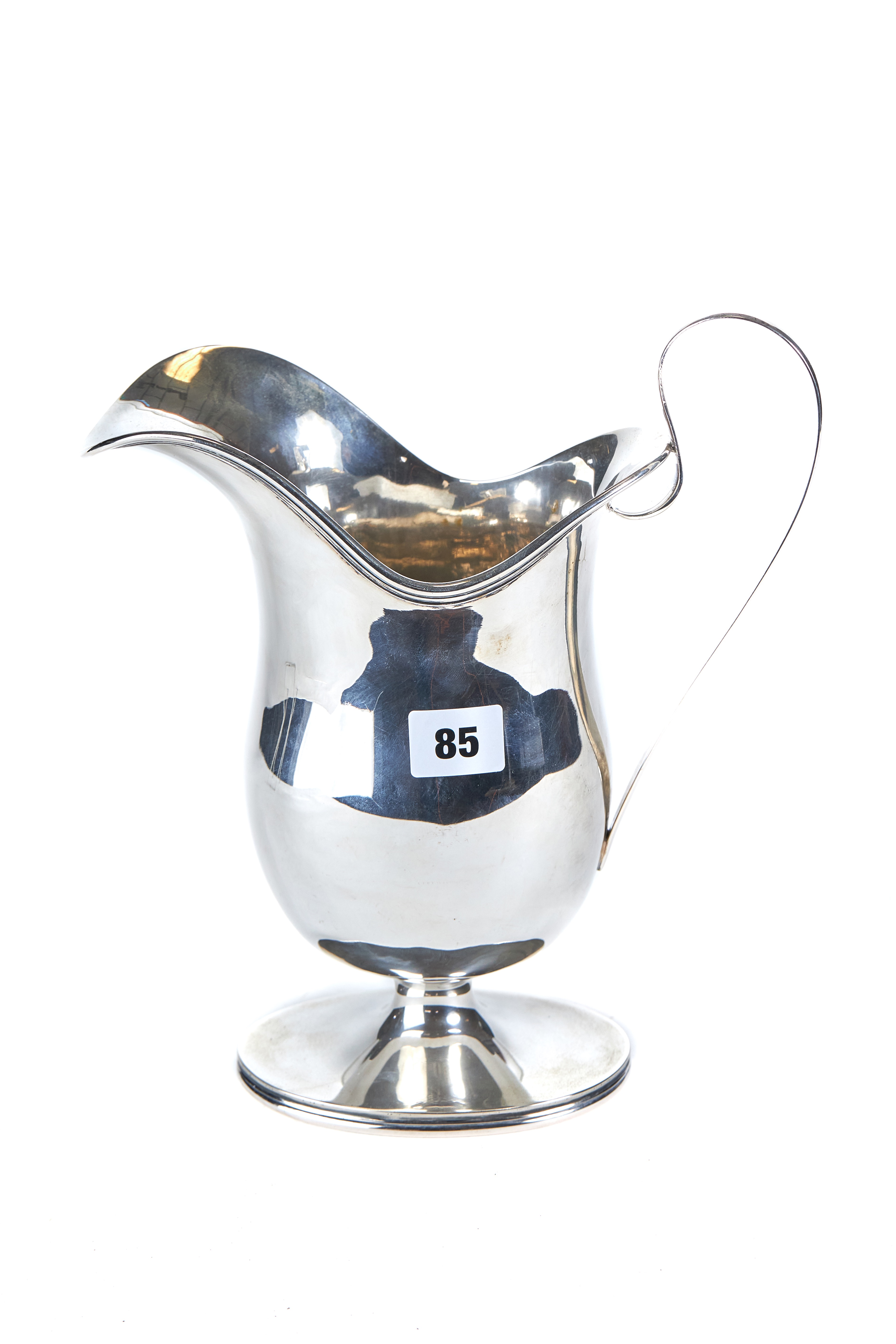 AN OVERSIZED CONTINENTAL WHITE METAL HELMET FORM JUG raised on an oval foot-rim, stamped 800,