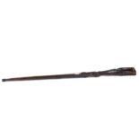 A VINTAGE AFRICAN WOOD RIFLE FORM WALKING STICK carved with a crocodile and two human heads,