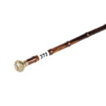 AN ANTIQUE WALKING CANE with jade knop inlaid with gold coloured metal.
