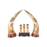 A PAIR OF 20TH CENTURY CARVED HORN ORNAMENTS decorated with four claw dragons, on wooden bases,