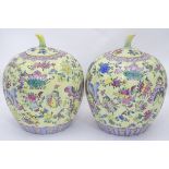 A pair of Chinese famille jaune ginger jars, decorated with flowers, butterflies, scrolls etc.