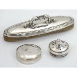 A oval nail buffer with a silver plate handle,