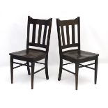 A pair of early 20thC Arts and Crafts ebonised slat back chairs with shaped top rail,