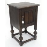 A bedside table with linen fold decoration,