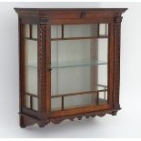 A mid 20thC oak wall hanging cabinet,