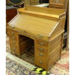 An early / mid 20thC tambour fronted desk with a moulded upstand above a sliding tambor front,