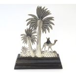 A Continental silver landscape scene depicting palm trees and a figure and camel with niello