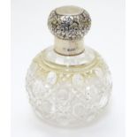 A cut glass dressing table scent / perfume bottle of spherical form with silver top hallmarked