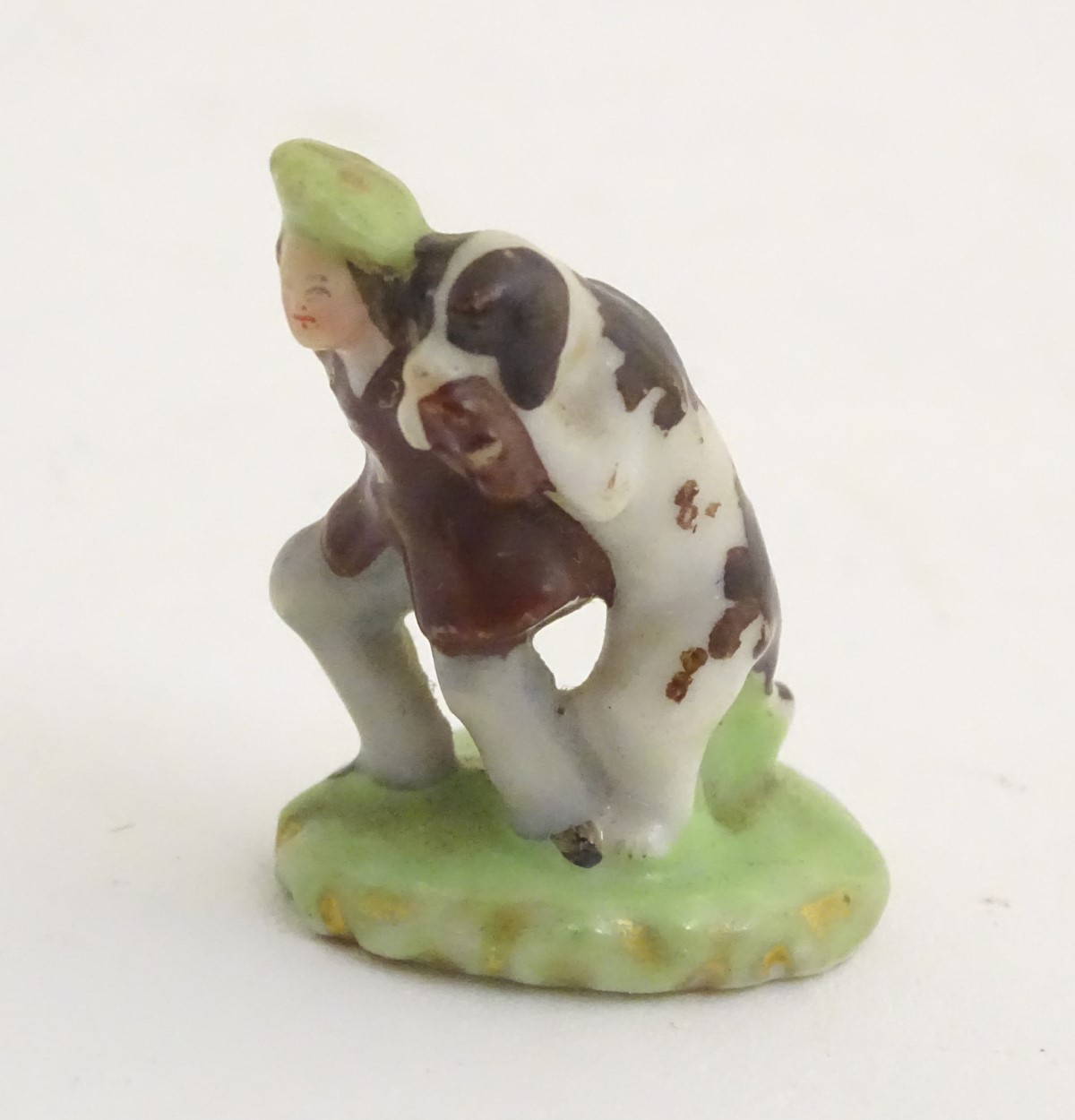 A miniature Rockingham style figure of a man wearing a tam-o-shanter with a dog on an oval base. - Image 4 of 7