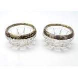 A pair of cut glass salts with silver rims hallmarked London 1917 Approx 2 3/4" diameter.
