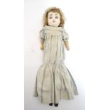 Toy: A wax headed doll with blue eyes, painted features, brown hair, composite forearms and calves,