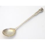 A silver spoon surmounted by angel head decoration,