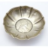 A small white metal dish with inset Austrian coin to base.