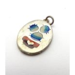 A silver pendant with enamel decoration depicting a stylised cactus.