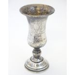 A silver kiddush cup with engraved decoration.