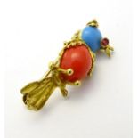 A yellow metal brooch formed as a bird on a perch,