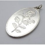 A silver pendant with rose decoration. Titled 'Suisse One ounce Fine Silver 999.