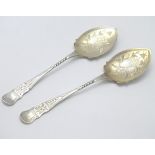 A Victorian pair of silver preserve spoons with engraved decoration and gilded bowls.