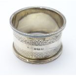 A silver napkin ring with engine turned decoration.