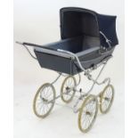 A 20thC Silver Cross coach built pram with a blue and white floral interior and a navy hood. Approx.