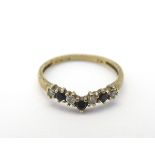 A 9ct gold ring set with white and black stones in a wishbone setting CONDITION: