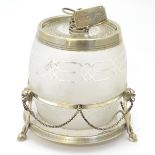 A glass and silver plate biscuit barrel on a silver plate stand.