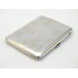 A silver cigarette case with gilded interior.