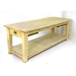 A large farmhouse kitchen table / preparation table with a plank top and short drawers to each end,