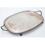 A silver plate tray with twin handles and four feet. 24 12" wide overall.