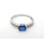 A 9ct white gold ring set with blue spinel flanked by diamonds.