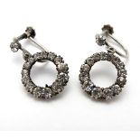 A pair of silver drop earrings set with white stones.